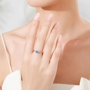 Anello minimalista in argento 925 con zircone blu cielo sulla mano di una modella