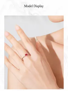 Close-up of S925 silver ring featuring an oval red zircon and side accents on a model