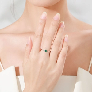 Elegant 925 sterling silver ring featuring a round green emerald zircon on a model hand