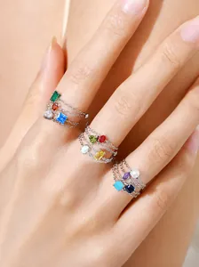 Nahaufnahme von drei Ringen aus 925er Sterlingsilber mit bunten Geburtsstein-Anhängern