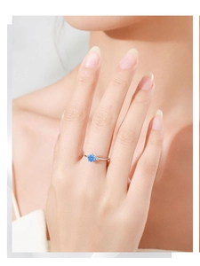 Detail of a slender S925 silver ring featuring a blue sapphire and small white zircon stones