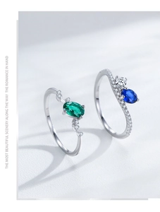 Close-up of S925 sterling silver rings with emerald and sapphire oval-cut cubic zirconia