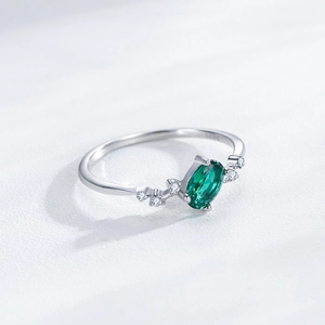 Elegante anello in argento 925 con smeraldo ovale e accenti di diamanti laterali