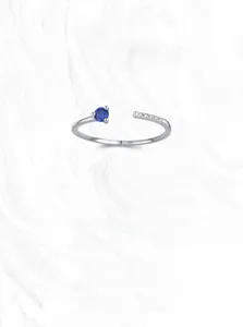 Detail of S925 sterling silver ring with blue gemstone and micro-pave white crystals