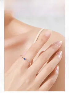 Detail view of adjustable silver ring with blue center stone and white accent stones