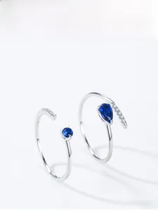 Detailed view of sterling silver rings set with blue pear-cut stones and white zircon crystals