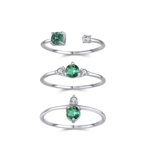 Three vintage S925 silver rings set with emerald green stones on white background
