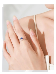 Detail of adjustable 925 silver ring featuring a pear-cut blue gemstone and micro-pave crystals