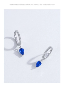 Dettaglio di orecchini a cerchio in argento 925 con goccia blu e pietre pavé