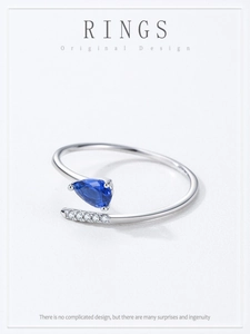 Dettaglio dell'anello d'argento con zircone blu a goccia e design a serpente incrociato