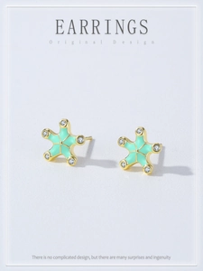 Detail view of gold starfish earrings with mint green enamel and white zircon stones