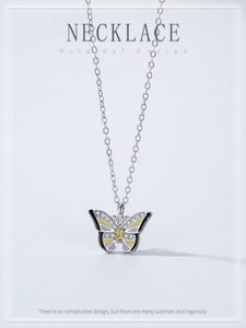 Detail of 925 silver butterfly pendant with yellow gemstone and enamel wings