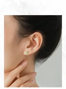 Close-up of mint green starfish stud earrings with crystals on a female ear model