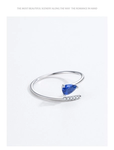 Dettaglio anello argento S925 con zircone blu a goccia e design a serpentina incrociata