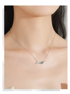 Detailed view of S925 sterling silver koi fish necklace with blue enamel on female model