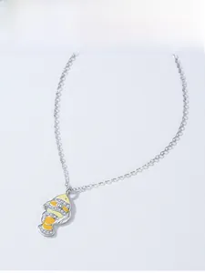 Macro detail of silver clownfish pendant with yellow enamel and sparkling zircon pave