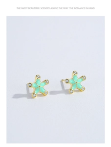 Detail of 925 silver mint green starfish earrings with gold base and small zircon stones