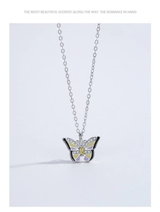 Detailed view of silver butterfly necklace with yellow zircon and purple enamel drip