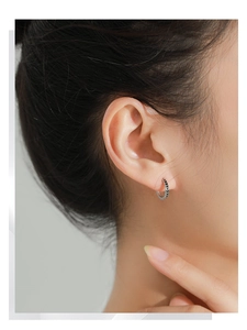 Close-up of minimalist 925 sterling silver hoop earring with black arrow enamel patterns