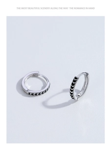 Detailed view of silver hoop earrings with black arrow pattern and secure clip closure