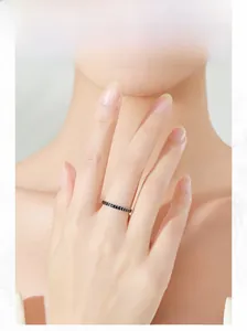 Model wearing a slim 925 silver ring with black V-shaped arrow patterns in minimalist style