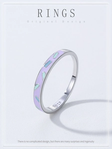Macro shot of 925 sterling silver ring with purple enamel and colorful capsule patterns