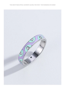 Detail of S925 silver ring with purple and green enamel waves and sparkling zircon stones