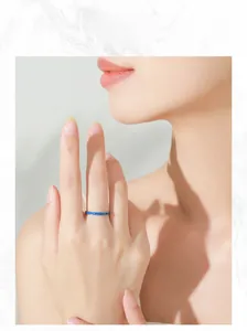 Close-up of minimalist S925 sterling silver ring with elegant blue enamel on female finger