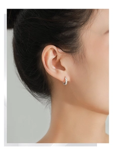 Close-up of S925 sterling silver hoop earring with LOVE engraving on female model