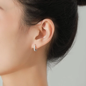 Minimalist S925 sterling silver hoop earrings with LOVE engraving shown on ear