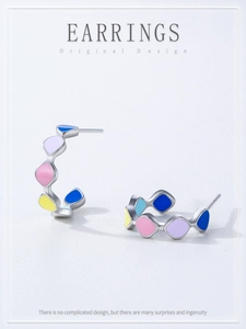 Detail of 925 sterling silver hoop earrings with colorful pastel enamel geometric patterns