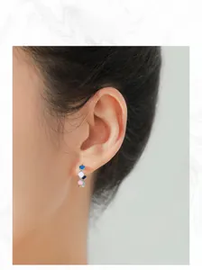 Close-up of colorful heart-shaped enamel hoop earrings on a model showing a trendy sweet look