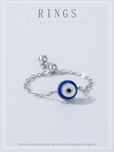 Macro detail of silver evil eye ring with adjustable chain and blue enamel charm