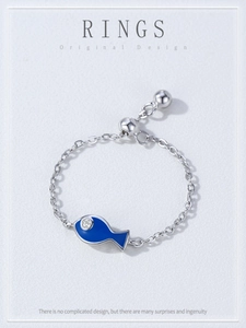 Macro detail of adjustable S925 silver chain ring with a blue enamel fish pendant