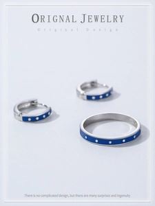 Detailed view of S925 silver ring and earrings set with blue enamel and white dots