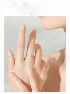 Close-up of minimalist 925 silver chain ring with yellow star charm on a model hand