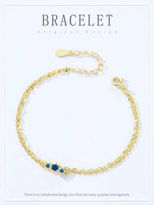 Close-up of S925 sterling silver gold bracelet featuring three blue zircon stones