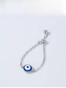 Macro detail of 925 sterling silver evil eye chain ring with blue enamel charm