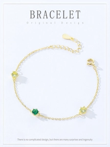 Detail of 925 sterling silver gold bracelet with round green and yellow zircon stones