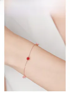 Close-up of rose gold silver bracelet with pink and red zircon stones on woman's wrist