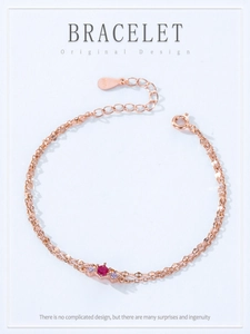 Detail of rose gold double-layer silver bracelet with red gemstone and purple crystals
