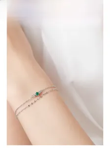 Detail eines doppellagigen 925 Silberarmbands mit grünem Edelstein am Handgelenk