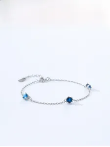 Macro view of S925 silver chain bracelet featuring three round blue faceted gemstones