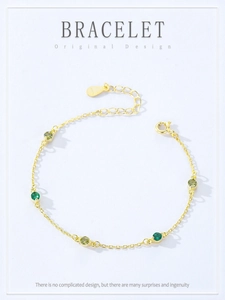 Detailed view of gold S925 silver bracelet with green gemstones and hallmark tag
