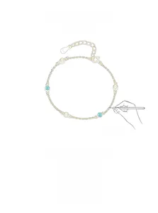 Detail of 925 silver gold bracelet with alternating green and yellow circular gemstones