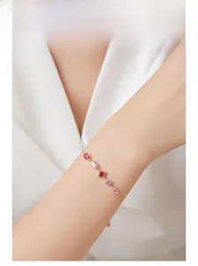 Close-up of rose gold silver bracelet with purple and pink gemstones on model wrist