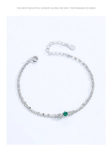 Makroaufnahme eines 925 Sterling Silber Doppelarmbands mit grünem Smaragd und Karabinerverschluss