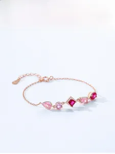Close-up of rose gold silver bracelet with pink zircons in various geometric shapes
