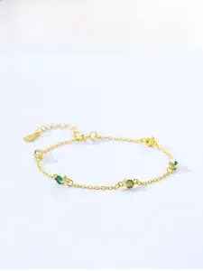 Detail of 925 silver gold bracelet featuring five round green gemstones in bezel settings