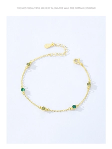 Macro view of gold 925 sterling silver bracelet with green cubic zirconia and S925 tag